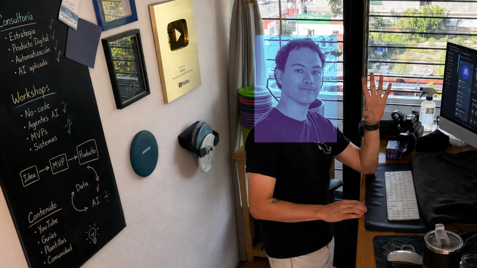 Fabián Oloarte in his teaching space beside a board filled with product, AI, and workshop notes.